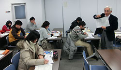 北海道新聞と読売新聞の社説のコピーを示しながら授業を進める北川保さん=11日、三重大