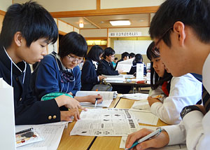 自分たちが作った高校新聞を見ながら18歳選挙権について議論する生徒たち=6日、士別市民文化センター
