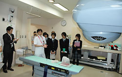 放射線治療装置の説明を受ける砂川高校生。左端が畑教諭＝９月３０日、札幌・北大病院