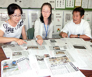 子供たちのスクラップノートを見ながら、震災関連記事を使ったＮＩＥ活動について語る（左から）米田、志賀、熊谷の３教諭