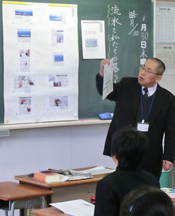 中日新聞（右側）と北海道新聞の流氷に関する記事を対比させながら授業を進める伊藤彰敏教頭