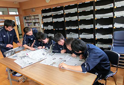 昼休みの図書室。生徒たちは棚から新聞を取り出し読み合っていた=20日