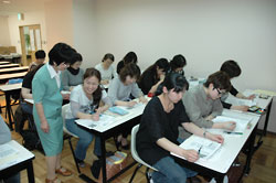 清藤講師（左）の指導で記事を朗読、内容を要約する「こども学舎」の学生