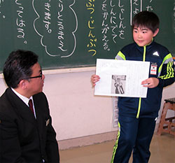 ワークシートを手にした子どもに発表の基本を指導する大武教諭（左）