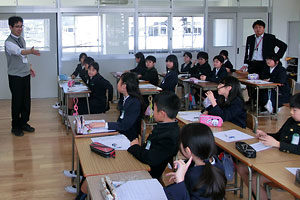 広島カープに復帰した黒田博樹投手の記事を使い、４年生のＮＩＥ授業を進める宮里洋司教諭（左）。右側は担任の岩本浩司教諭