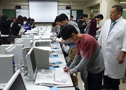 手書き新聞を審査する月寒高定時制の２年生たち。右端は青島正樹教諭
