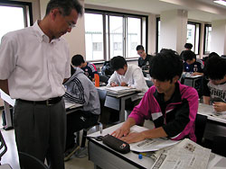 ＮＩＥ講座で、学生の新聞スクラップ作りを指導する福沢さん