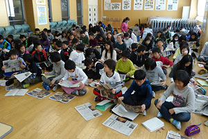 北海道新聞の出前講座で配られた新聞を見る屯田北小の５年生たち