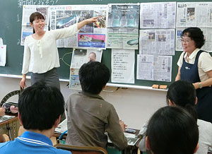 道新の紙面と号外を使って授業を進める横尾教諭(左)と村上さん