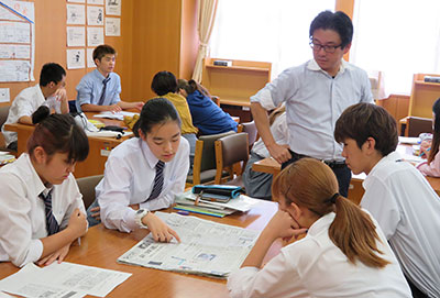 現代社会の授業で、新聞６紙を読む都立国際高校の生徒と、担当教諭の宮崎さん＝１１日