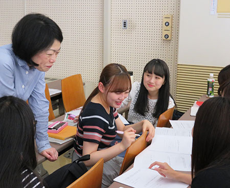 学生のグループ討議を指導する石川由香里教授(左)。時には同じ女性目線での助言も