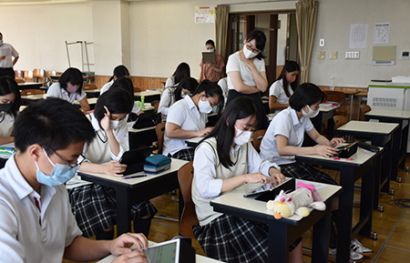 新聞社説をタブレット端末で読んで要旨を送信する札幌光星高生たち